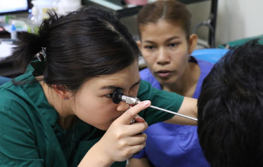 An Audiology student pictured testing the hearing of a young boy