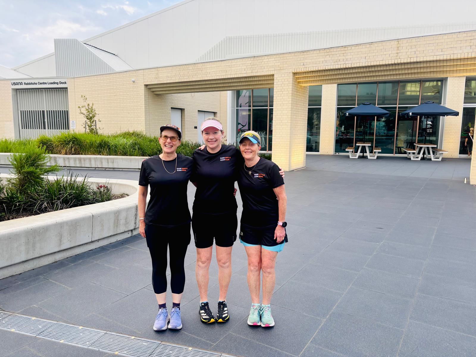 Group photo of three people in 'can walk can run' shirts