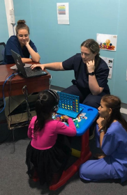 Three audiologists working with a child
