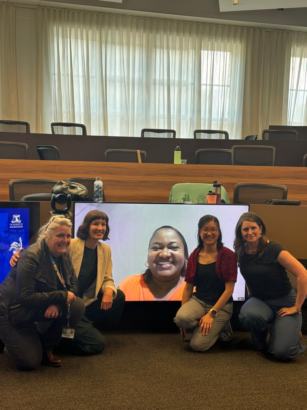 Moyotrak team posing with person on screen