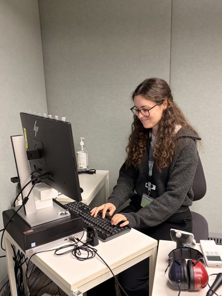 Person in an indoor room with hearing test equipment
