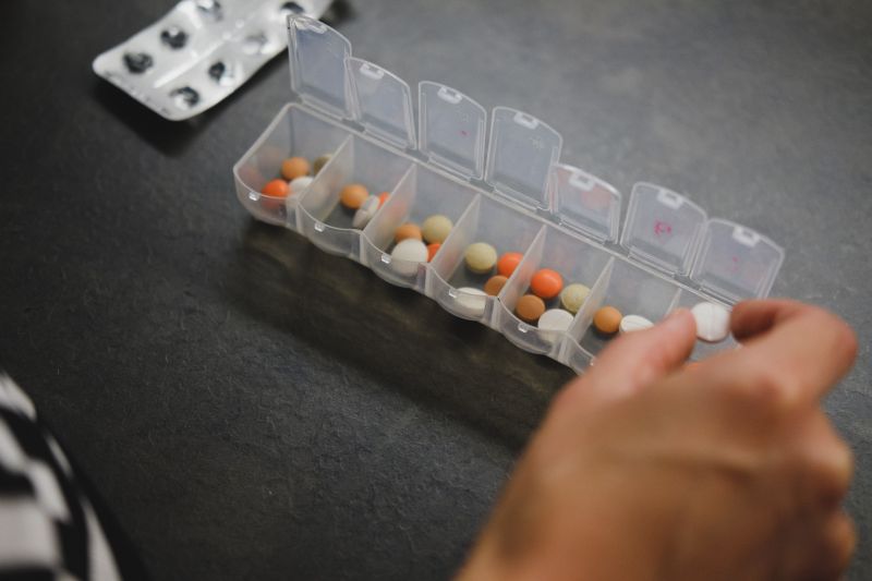 Pill tray with female hands organising