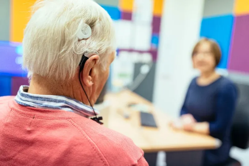 a person with a cochlear implant and another person in conversation