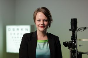 Dr Lauren Ayton pictured in front of optometry equipment